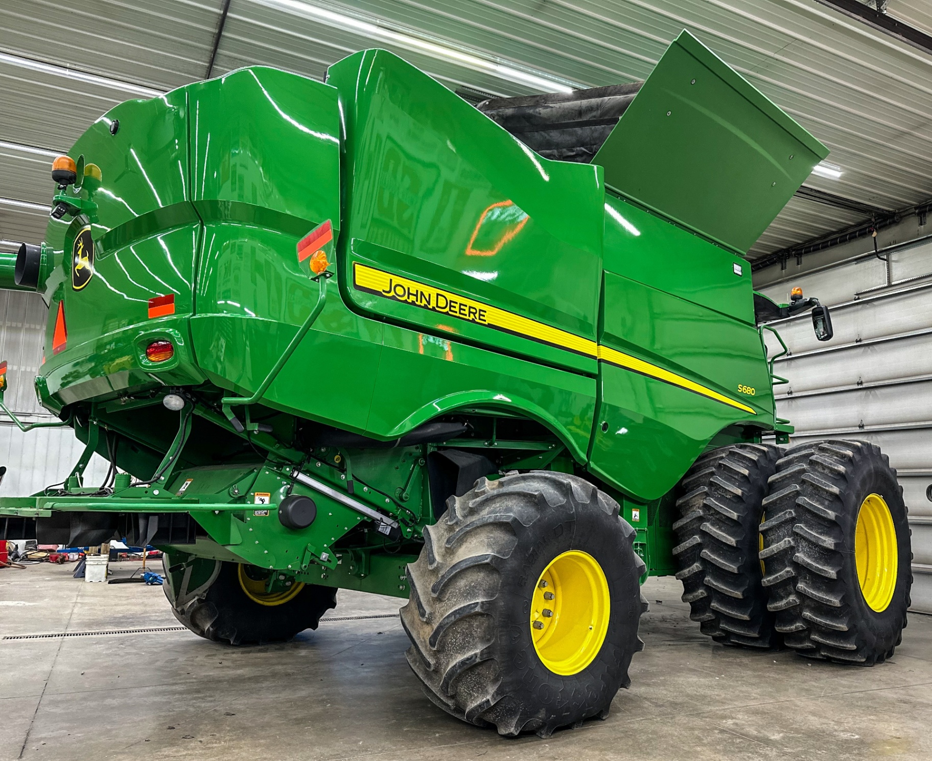 John Deere S680 combine with a deep gloss green finish in a farm shop