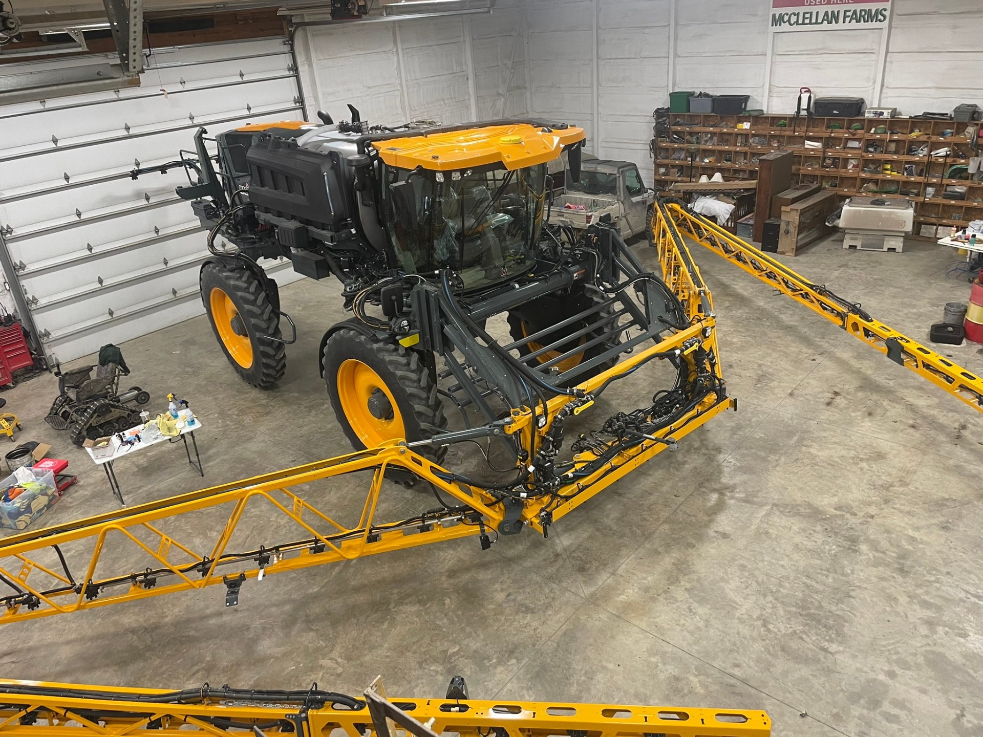 Self-propelled ag sprayer with boom arms in a farm shop