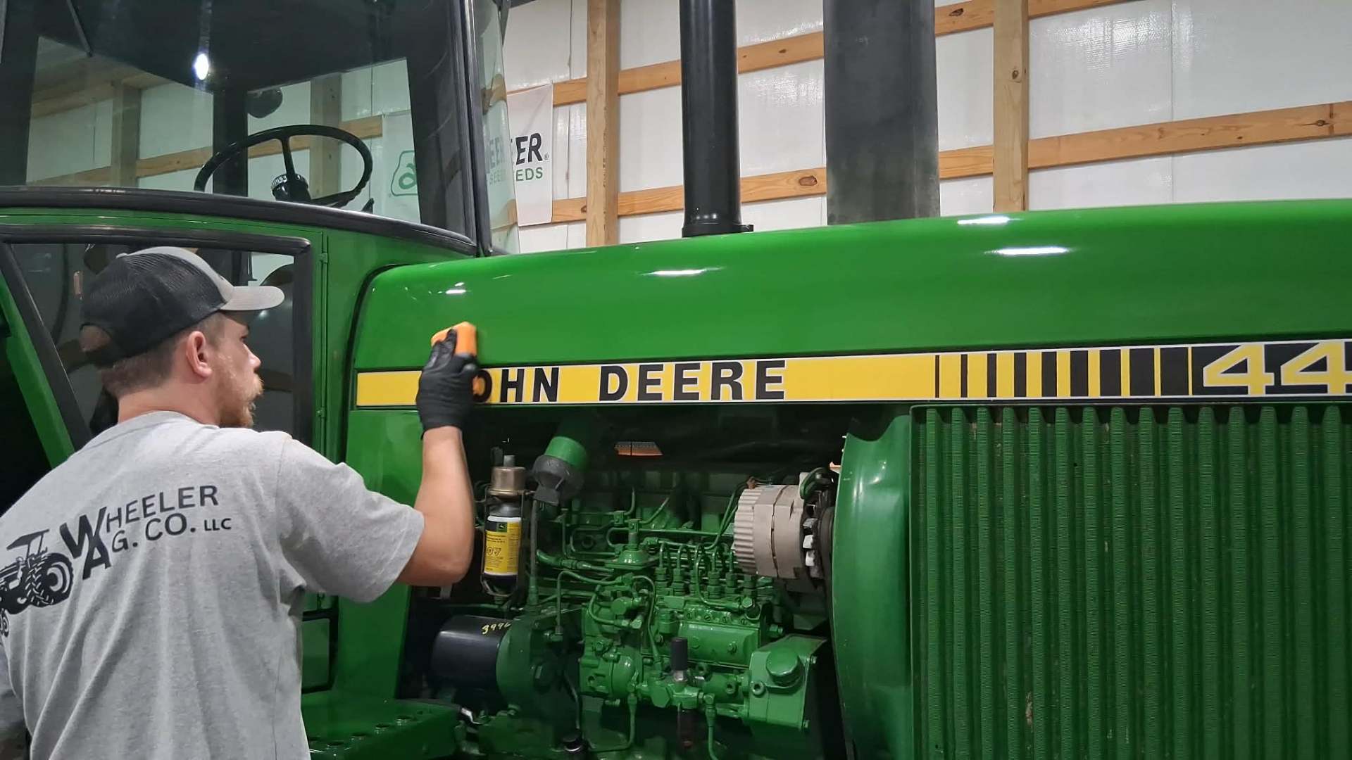 Jeremiah Wheeler applying Roar ceramic coating to a John Deere 4455 tractor hood