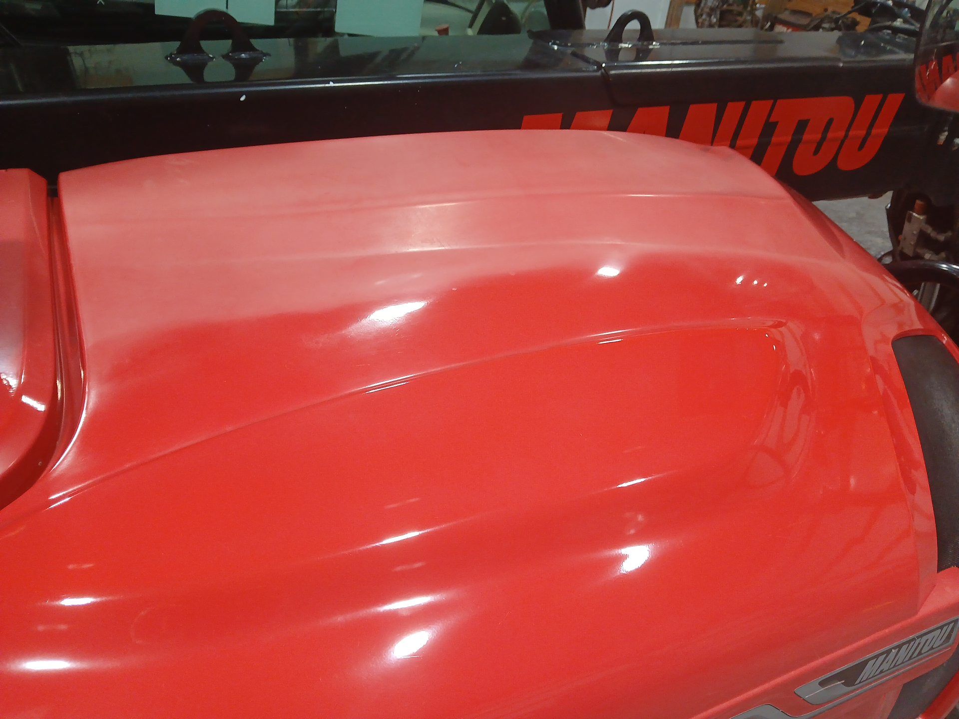 Close-up of restored red equipment paint reflecting overhead lights