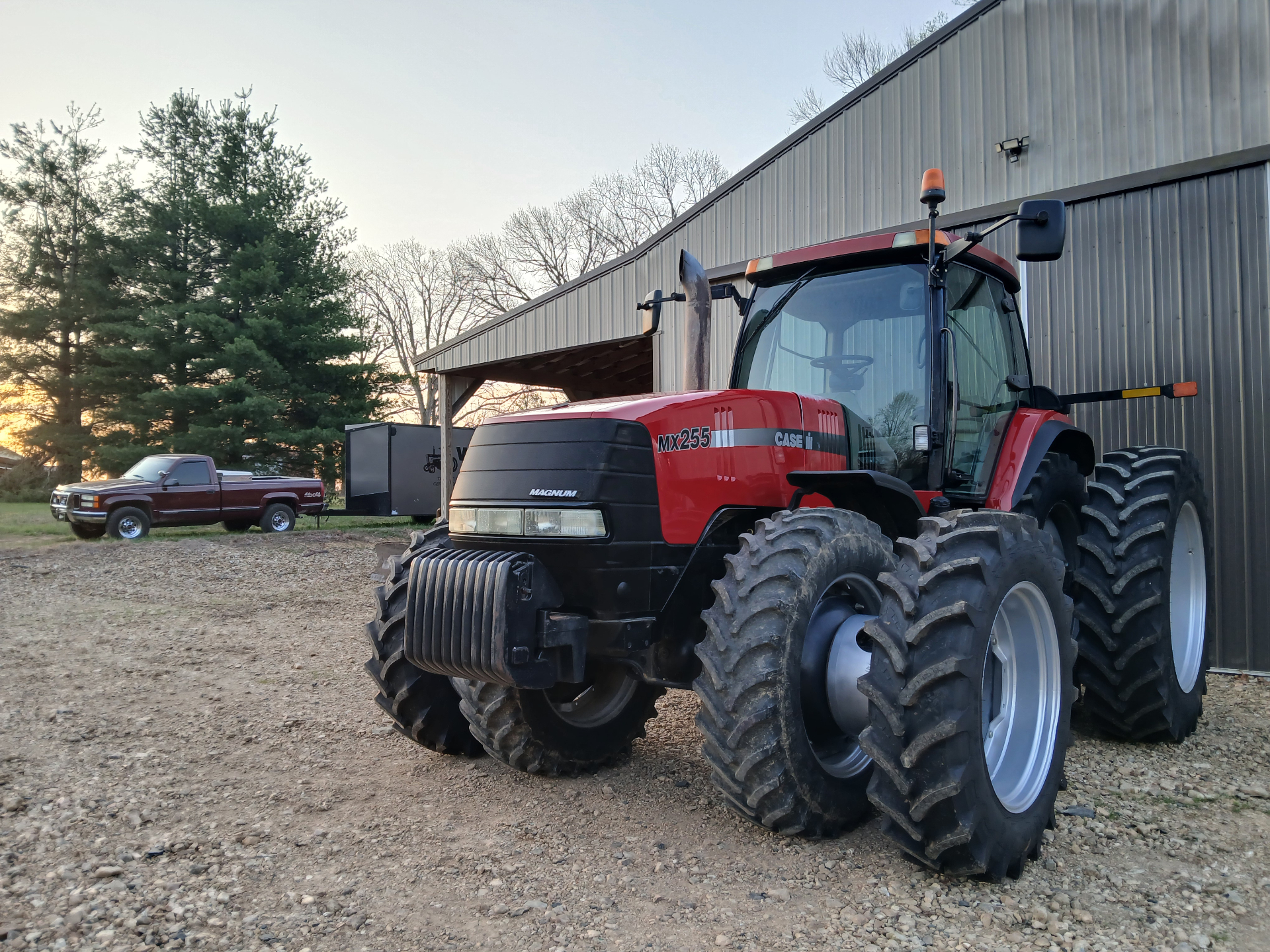 Case IH tractor parked outside a farm building at sunrise